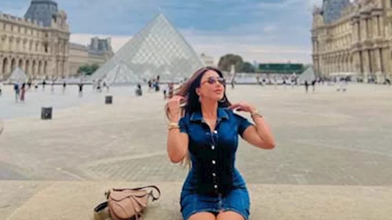 السداد | 15 صورة لـ سارة سلامة أمام اللوفر بفستان أزرق قصير